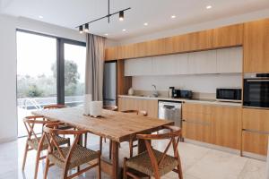 eine Küche mit einem Holztisch und einigen Stühlen in der Unterkunft Oasis Villa 6 in Klorakas