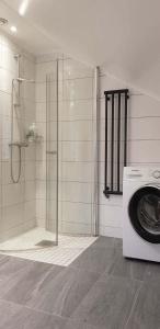 a bathroom with a shower and a washing machine at Gula Huset in Gothenburg +21 photos