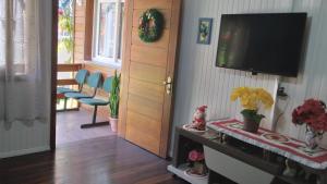 a living room with a flat screen tv on a wall at Pousada Genial in Gramado