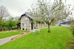 una casa con un albero nel cortile di Gite Cottage de la Douloustre a Montgaillard