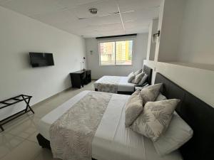 a hotel room with two beds and a television at HGO Hotel in Cali +62 photos
