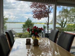 a dining room table with a vase of flowers on it at Ferienhaus In Klingberg Mit Seeblick in Scharbeutz