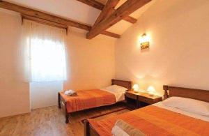a room with two beds and a window in it at Ferienhaus In Radići Mit Privatem Pool in Jakići +13 photos