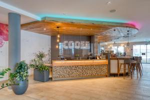 a restaurant with a food counter and a restaurant at COOEE alpin Hotel Bad Kleinkirchheim in Bad Kleinkirchheim