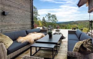 a patio with a blue couch and a table at Awesome Home In Norheimsund With Sauna in Norheimsund