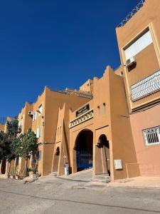 a building with a sign on the front of it at Tradition & Tranquility in Tamraght Ouzdar