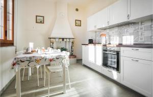 eine Küche mit einem Tisch und einigen weißen Schränken in der Unterkunft Stunning Home In Ponte Buggianese in Ponte Buggianese