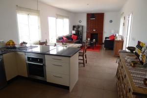 a kitchen with a counter top and a living room at Casa Jamila in El Alquián