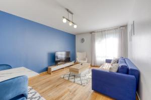 a living room with a blue couch and a tv at Room Proche Paris & Bercy 2 - Cozy Houses in Charenton-le-Pont