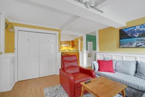 a living room with a couch and a red chair at Artsy Private Guest Suite with Outdoor Saloon in Vancouver