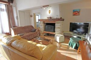 Una sala de estar con un sofá y una chimenea. en Saint roch 87, en Eyjeaux