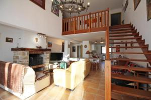 sala de estar con sofás, escalera y chimenea en Saint roch 87, en Eyjeaux