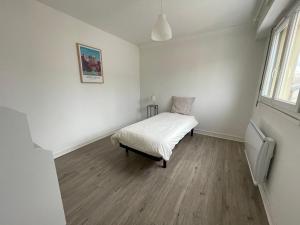 ein weißes Schlafzimmer mit einem Bett in einem Zimmer in der Unterkunft Appartement T4 Centre Ville C3 in Châteauroux