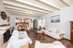 a living room with white furniture and a fireplace at Villa Theodora in Nisakion