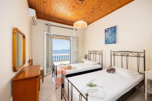 two beds in a room with a view of the ocean at Villa Theodora in Nisakion +28 photos