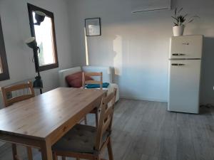 a dining room with a wooden table and a refrigerator at Apartamento rural con vistas in Miraflores de la Sierra