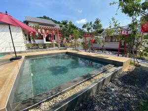 a swimming pool in the yard of a house at Taka Onzen in Ban Khao Ket