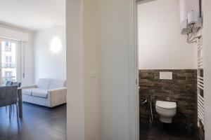 a bathroom with a toilet and a couch at Lungarno Apartment in Florence