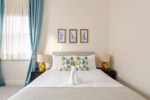 史云顿Stylish flat in central location with free parking的卧室配有带两盏灯的白色床