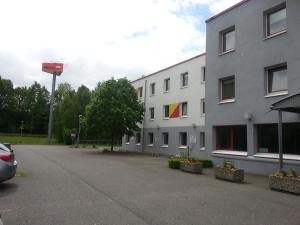 um parque de estacionamento em frente a um edifício branco em Motel 24h Bremen em Bremen