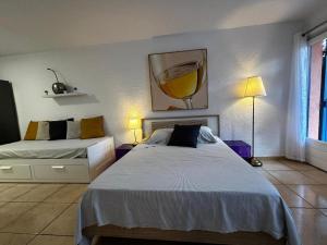sypialnia z dwoma łóżkami i obrazem na ścianie w obiekcie Lumineux Studio tout équipé w mieście Canet-en-Roussillon