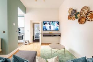 史云顿Stylish flat in central location with free parking的带沙发和桌子的客厅