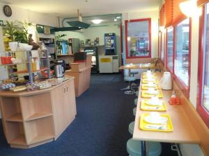 a restaurant with a row of tables in a room at Motel 24h Bremen in Bremen