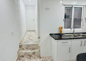 a kitchen with white cabinets and a sink at Apartamento Noori 1B in Vinaròs