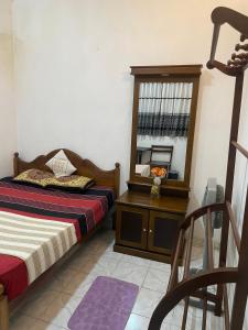 a bedroom with a bed and a mirror and a chair at Suriya Haven Homestay in Badulla +35 photos