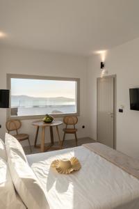 a bedroom with a white bed and a table at Mirabo Villas in Firostefani +82 photos