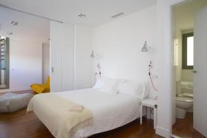 - une chambre avec un lit blanc et une salle de bains dans l'établissement PG3 - Ático en Paseo de Gracia, à Barcelone