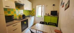 una pequeña cocina con mesa, mesa y sillas en Charming apartment in the historic heart, en Fréjus