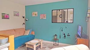 a living room with a couch and a blue wall at a lovely nest in Bussy-Saint-Georges