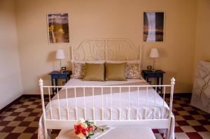 a bedroom with a white bed with two tables at Palazzo Fiammingo Rooms in Belpasso +35 photos