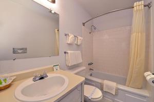 a bathroom with a sink and a toilet and a tub at The Maverick Motel, Main Street USA Collection by PNW Hospitality in Klamath Falls +12 photos