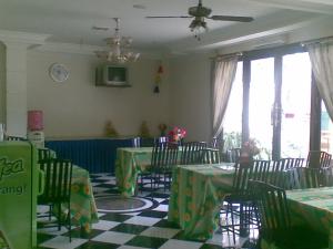 een restaurant met tafels en stoelen en een plafondventilator bij Hotel Ronggolawe in Cepu