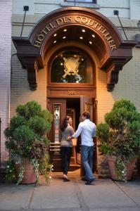 
a man and woman standing outside of a building at Hôtel des Coutellier in Quebec City
