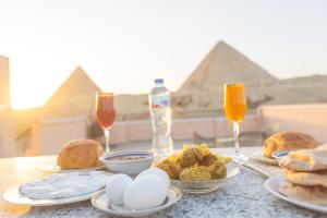 a table with eggs and bread and two glasses of wine at Grensha Pyramids inn in Cairo