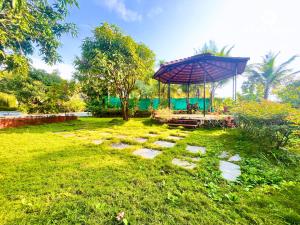 a garden with a gazebo in a park at StayMist - Casa Miralys in Nagaon