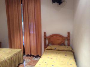 ein Schlafzimmer mit einem Bett und einem Kinderbett in einem Zimmer in der Unterkunft Pensión Princesa in Granada