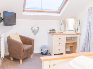 a living room with a chair and a tv at Lakeland View in Keswick