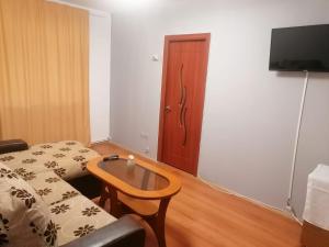 a room with a couch and a table and a television at Dâmb 2 camere in Târgu-Mureş