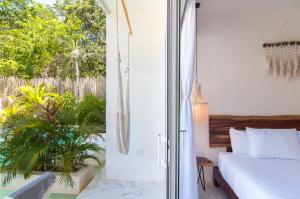 une chambre avec un lit et une porte coulissante en verre dans l'établissement Studios in Tulum by Casago, à Tulum 67 autres photos