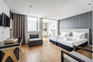 a hotel room with a bed and a chair at Sé INN Studios by House and People in Braga