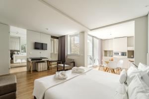 a bedroom with a large white bed and a living room at Sé INN Studios by House and People in Braga +128 photos