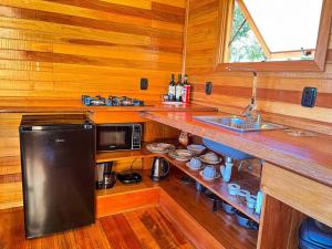 a kitchen with a counter with a sink and a microwave at Chalé da Mata em Nova Petrópolis in Nova Petrópolis