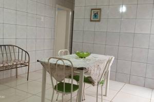 a white table and chairs with a green bowl on it at Casa Prox Centro in Ribeirão Preto +9 photos