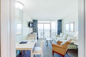 a living room with a couch and a table at Camelot by the Sea 1506 in Myrtle Beach