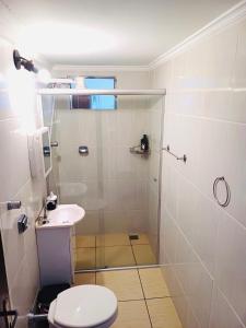 a bathroom with a shower and a toilet and a sink at Suite na Casa Azul in Socorro