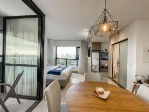 a living room with a bed and a dining room table at A Melhor Vista de Campo Grande in Campo Grande